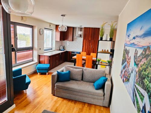 a living room with a couch and a kitchen at Wola Park Apartament - Self Check-In Klimatyzacja, Metro Ulrychów, Garaż-Gratis in Warsaw