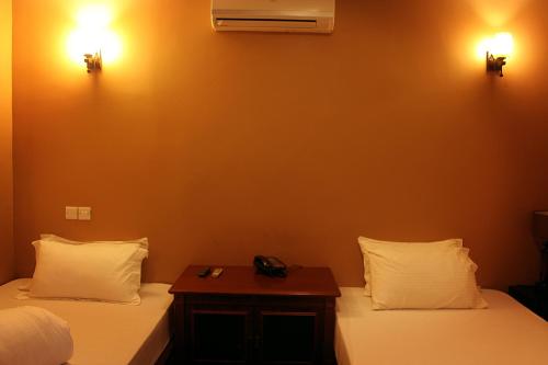 two beds in a room with two lights on the wall at Tulia Boutique Hotel & Spa in Arusha