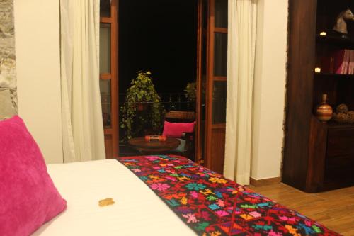 a bedroom with a bed with a colorful blanket on it at Hotel Boutique La Casona de Don Porfirio in Jonotla