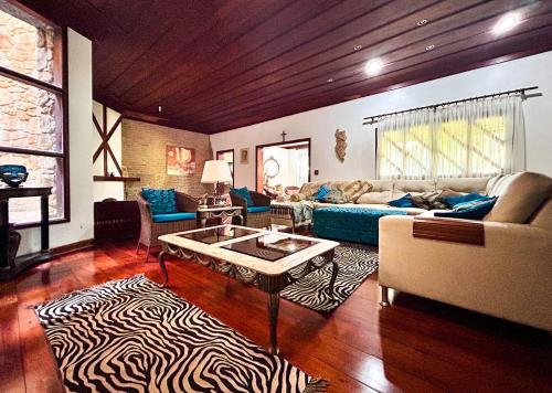 a living room with a couch and a table at Incrivel casa com lazer completo e WiFi -Ibiuna SP in Ibiúna