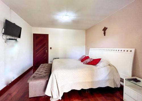 a bedroom with a bed with red pillows on it at Incrivel casa com lazer completo e WiFi -Ibiuna SP in Ibiúna
