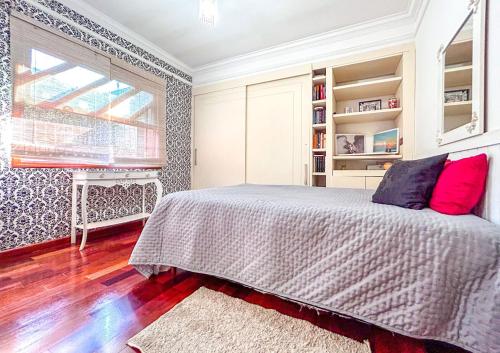 a bedroom with a bed with red pillows and a window at Incrivel casa com lazer completo e WiFi -Ibiuna SP in Ibiúna