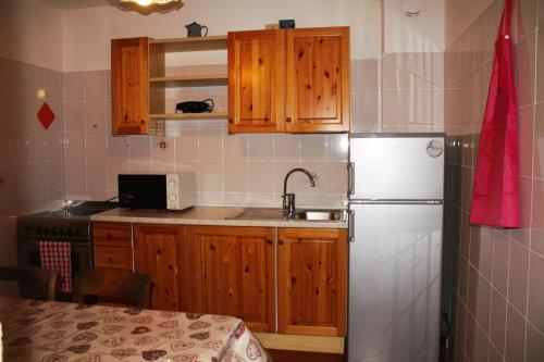 a kitchen with wooden cabinets and a refrigerator at Chalet Renzo in Livigno