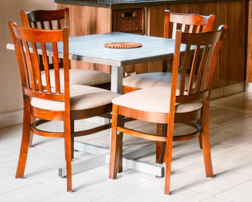 a dining room table with four chairs around it at Umkhaya lodge in Mkuze