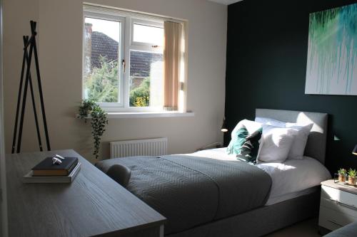 a bedroom with a bed with a table and a window at 5 star, 5 Bedroom Home in Ely in Ely