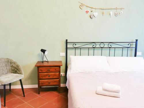 a bedroom with a bed and a chair and a nightstand at CASA ARYA - Independent House - Near the Walls in Lucca