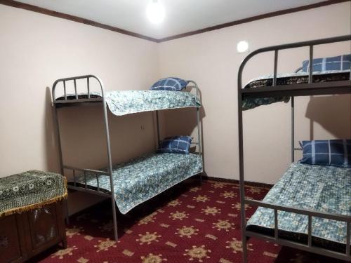 um quarto com 2 beliches e um tapete vermelho em Hostel Yak-Shab em Dushanbe