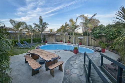 a swimming pool with a table and chairs in a yard at Sport Of Kings Motel in Rotorua