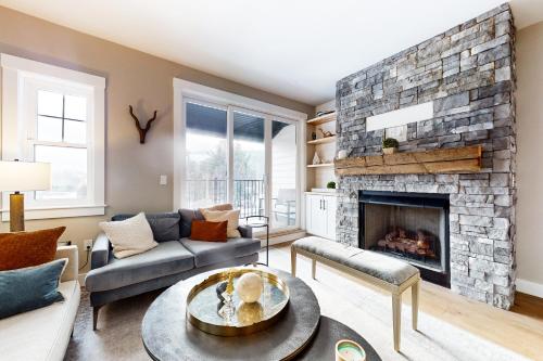 a living room with a stone fireplace at Mountain Sunset Villa in Waterville Valley