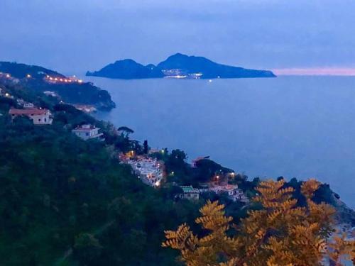 a town on a hill next to a body of water at Bilocale panoramico “Lo sguardo” in Massa Lubrense