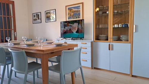 een eetkamer met een houten tafel en stoelen bij Villa Duna Verde in Duna Verde