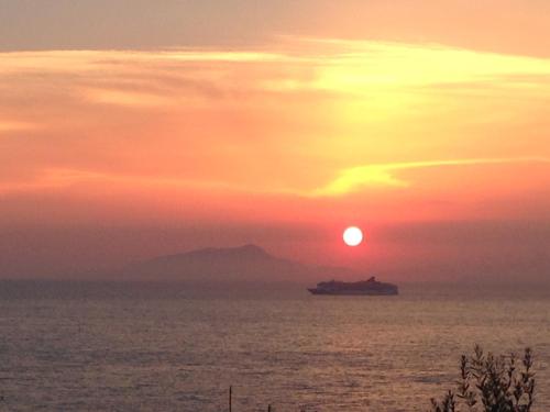 a cruise ship in the ocean at sunset at Bilocale panoramico “Lo sguardo” in Massa Lubrense