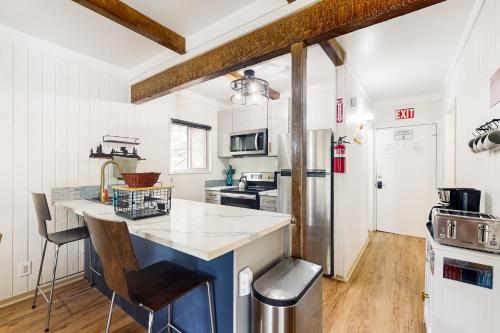 a kitchen with white walls and a blue island at Whispering Trees in Fish Camp