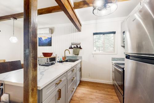 a kitchen with white cabinets and a sink and a refrigerator at Whispering Trees in Fish Camp