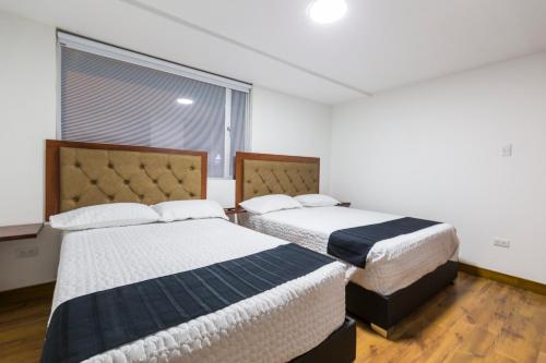 1 dormitorio con 2 camas y ventana en Hotel Casa Botero 202, en Bogotá