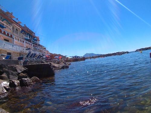 a body of water next to a beach with buildings at Bilocale panoramico “Lo sguardo” in Massa Lubrense