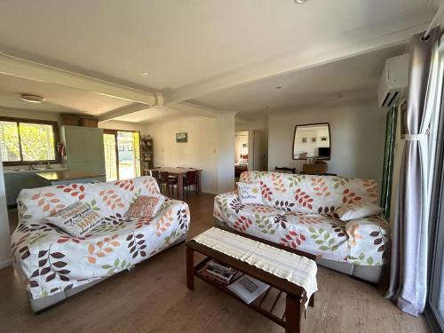 a living room with two couches and a table at Camelot in Yamba