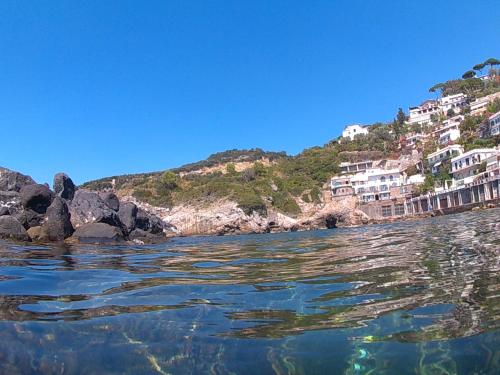 a body of water with houses on a hill at Bilocale panoramico “Lo sguardo” in Massa Lubrense