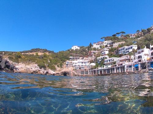 a group of houses on a hill next to the water at Bilocale panoramico “Lo sguardo” in Massa Lubrense