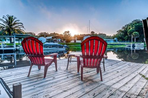 two red chairs and a table on a dock at The Water Lily Lodge in Inverness