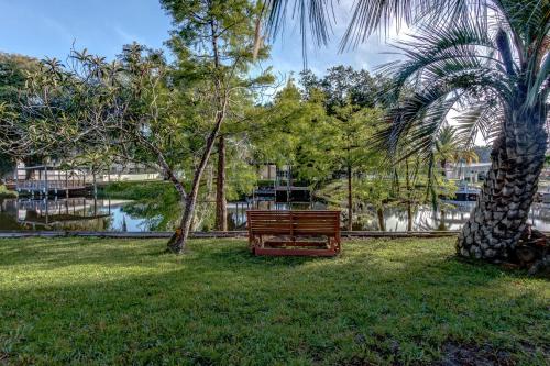 a park bench sitting in the grass next to a palm tree at The Water Lily Lodge in Inverness