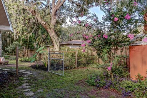 a yard with a gate and a tree with pink flowers at The Water Lily Lodge in Inverness