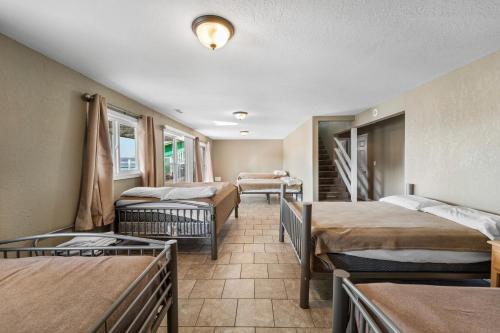 a room with three beds and a staircase at Shady Gator House Sleep 20 Bachelor and Bachelorette Parties Welcome in Lake Ozark