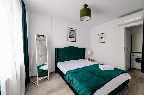 1 dormitorio con 1 cama con cabecero verde y espejo en Happy Heart Hideaway, en Bucarest