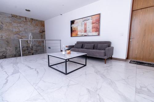 a living room with a couch and a table at Urban Puebla by Grupo Amber in Puebla