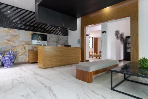 a lobby with a bench and a table at Urban Puebla by Grupo Amber in Puebla