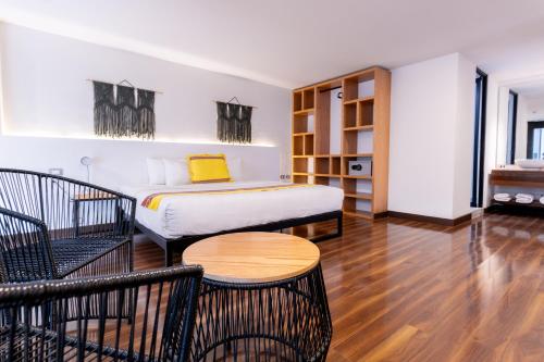 Schlafzimmer mit einem Bett, einem Tisch und Stühlen in der Unterkunft Urban Grupo Amber - Collection O in Puebla