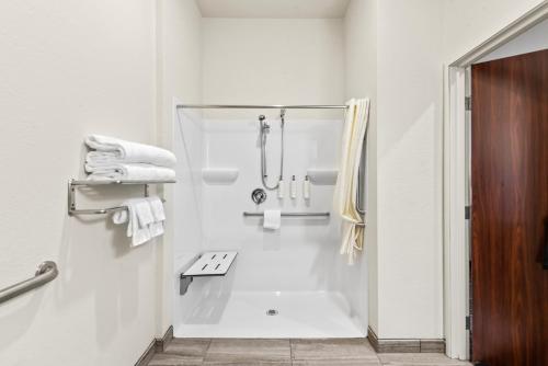 a white bathroom with a shower and a sink at Cobblestone Hotel & Suites - Cullman in Cullman
