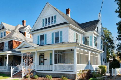 a white house with large windows and a porch at Stylish Victorian in Historic District in Cambridge