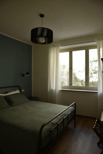 Schlafzimmer mit einem Bett und einem Fenster in der Unterkunft Sky & Vineyards - Mora - in La Morra