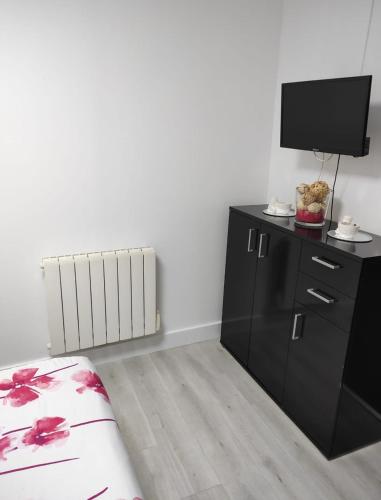 a bedroom with a bed and a tv and a dresser at Charmante Maison à Hérin-plain-pied, clim,Wi-Fi in Hérin