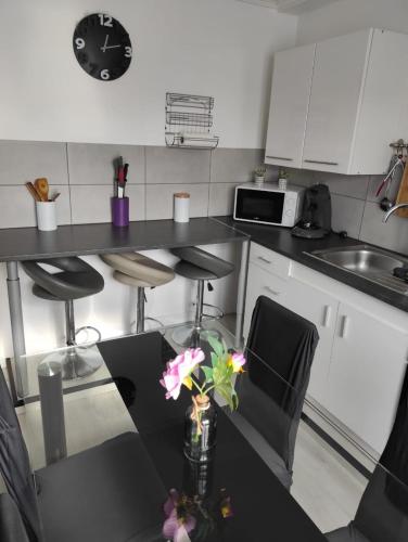 a kitchen with a table with a vase with flowers on it at Charmante Maison à Hérin-plain-pied, clim,Wi-Fi in Hérin