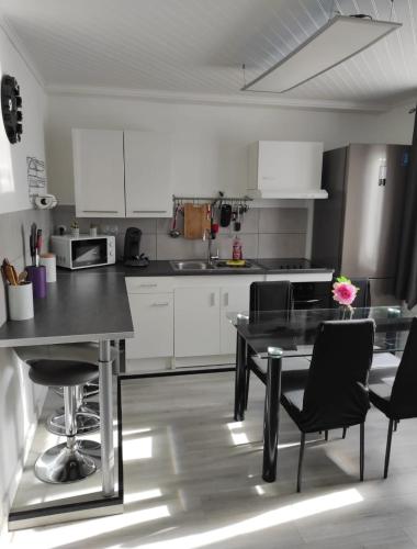 a kitchen with a table and chairs in a room at Charmante Maison à Hérin-plain-pied, clim,Wi-Fi in Hérin