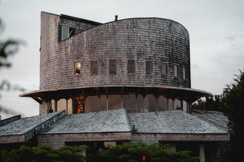 a round house with a gambrel roof on top of a house at Lodge Parque Tepuhueico in Castro