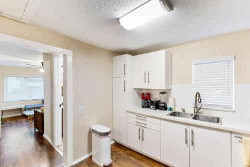 eine Küche mit weißen Schränken und einem Waschbecken in der Unterkunft The City Perch in Austin