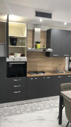 a kitchen with black cabinets and a sink at b&b Santa Maria in Santa Maria a Vico