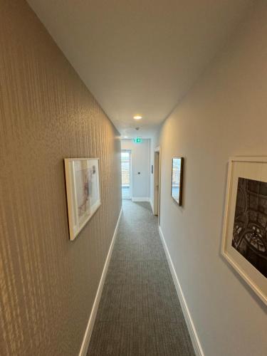 a hallway with paintings on the walls of a house at LUXX Apartment & Suites, London Heathrow Airport, Terminal 4, Piccadilly underground Train station nearby! in New Bedfont