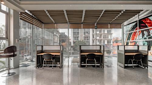 Habitación con 2 escritorios, sillas y ventanas en Elegante LOFT 6 con vista a la ciudad, en Ciudad de México