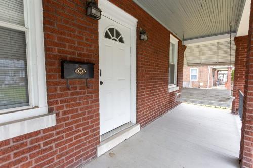 a brick building with a white door and a porch at Rolston 1 Bedroom House near Xavier, Downtown in Bellevue