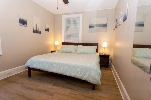 - une chambre avec un lit avec des draps blancs et 2 lampes dans l'établissement New Listing - 1 Bed House experienced super host, à Bellevue