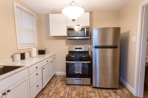 a kitchen with a stainless steel refrigerator and a stove at Rolston 1 Bedroom House near Xavier, Downtown in Bellevue