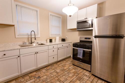 a kitchen with white cabinets and a stainless steel refrigerator at Rolston 1 Bedroom House near Xavier, Downtown in Bellevue