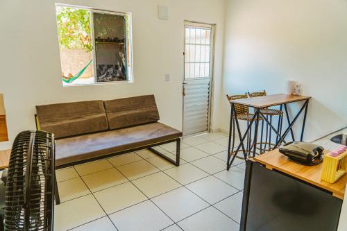 ein Wohnzimmer mit einem Sofa und einem Tisch in der Unterkunft Chale com excelente localizacao e WiFi em Parnaiba in Parnaíba