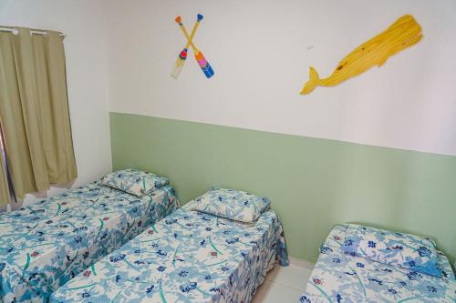 Zimmer mit 2 Betten und einem Zauberstab an der Wand in der Unterkunft Chale c otima localizacao e Wi-Fi em Parnaiba PI in Parnaíba