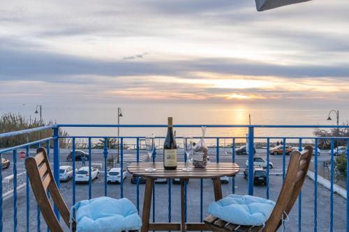 a table with a bottle of wine sitting on a balcony at Orizzonte in blu in Anzio