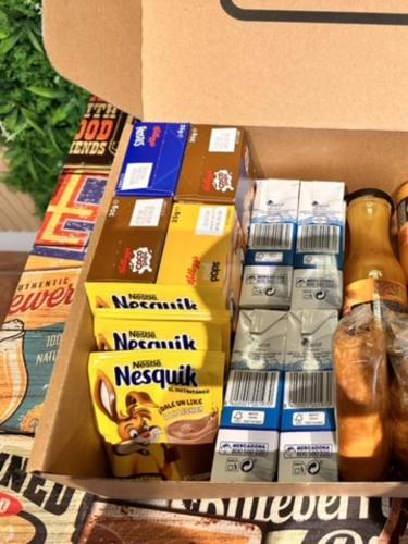 una caja llena de cajas de comida y una botella en IFEMA APARTMENT - Aeropuerto y Feria a tu Alcance, en Madrid